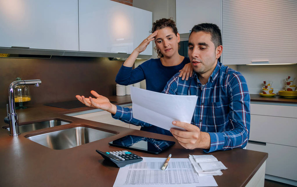 unemployed young couple with debts reviewing their bank accounts